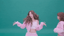 two women in pink sweatshirts are playing with their hair