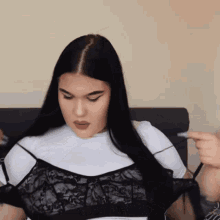 a woman wearing a white shirt and a black bra