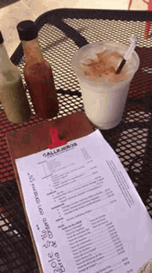 a drink and a menu are on a table .