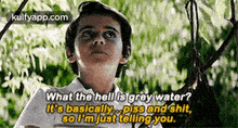a young boy is standing in front of a tree and talking to a tree .