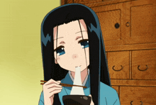 a girl with long black hair and blue eyes is eating something with chopsticks
