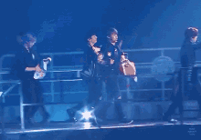 a group of people standing on a stage with a sign that says ' korean ' on it .