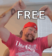 a man wearing a red hat and a pink shirt holds his arms up in front of a free sign