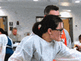 a woman wearing glasses is standing next to a man wearing an apron that says ' srk ' on it