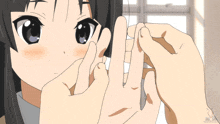 a person holding a piece of paper in front of a girl 's eyes