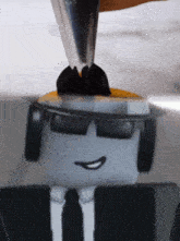 a toy car wearing a suit and tie is being screwed into a wall