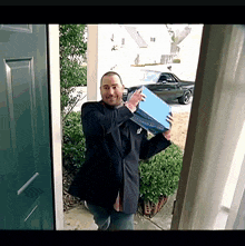 a man in a suit is holding a blue box that says ' ford ' on the front