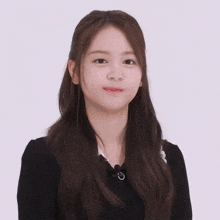 a young woman with long brown hair is wearing a black sweater