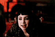 a blurry picture of a woman sitting at a table in a dark room