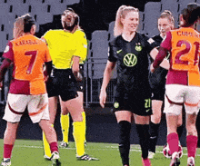 a group of female soccer players are standing on a field with one wearing the number 7