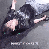a man is laying on the floor with a microphone in his hand and headphones on .