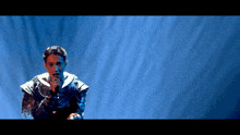 a man singing into a microphone on a stage