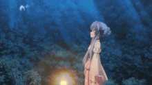 a girl in a pink dress reaches out towards a lantern in the dark
