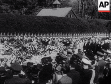 a group of people are gathered in front of a fence with the letters ap on the bottom right