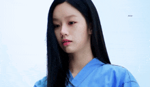 a close up of a woman wearing a blue scrub top