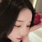 a close up of a woman holding a red apple in her hand