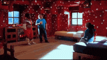 a man in a blue shirt is standing in a room with red walls