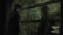 a man stands in front of a wall with plaques on it that say keith park