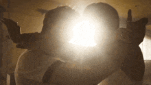 a man is holding a baby in his arms while the sun shines through the window behind them