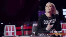 a woman wearing a black shirt that says couture is an attitude