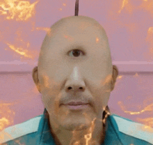 a bald man with a third eye on his forehead is standing in front of a pink wall .