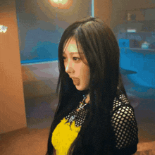 a woman with long black hair is standing in a room