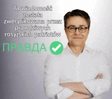a man with his arms crossed stands in front of a sign that says ta wiadomosc