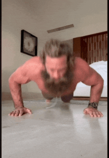 a shirtless man with a beard is doing push ups on a floor