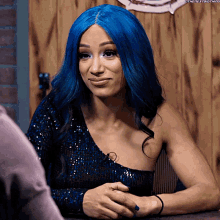 a woman with blue hair is wearing a blue sequined top