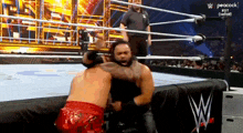 two men are wrestling in a wrestling ring on peacock .