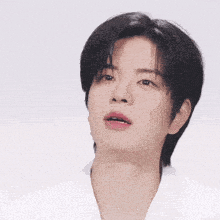 a close up of a young man wearing a white shirt