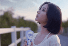 a woman is holding a blueberry flavored drink