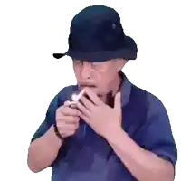 a man wearing a hat is lighting a cigarette with a lighter