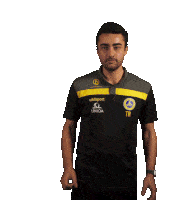 a man wearing a black shirt that says uhlsport on the front