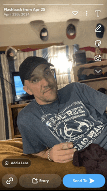 a man wearing a fender t-shirt is sitting on a couch
