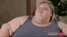 a very fat woman is sitting on a couch .