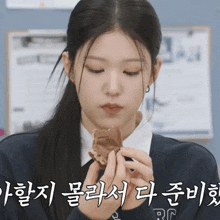 a girl eating a piece of food with chinese writing on the bottom right
