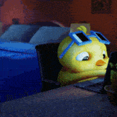 a cartoon duck wearing sunglasses sits at a desk with a laptop