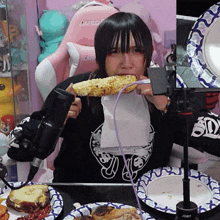 a girl eating corn on the cob with a purple cord