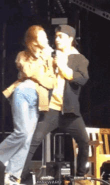 a man is holding a microphone while a woman stands behind him