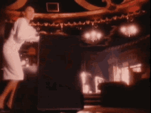 a woman in a white dress is dancing in a room