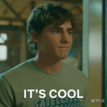 a young man wearing a shirt that says it 's cool