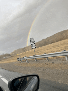 a rainbow appears over a sign that says north 318 and 231
