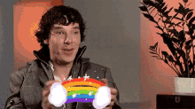 a man is holding a rainbow in his hands