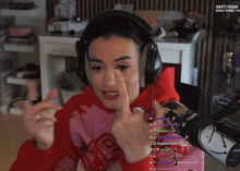 a woman wearing headphones and a red sweatshirt with the word vir on it