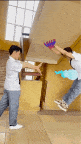 a man in a white shirt is holding a blue balloon while another man in a blue shirt is holding a blue glove
