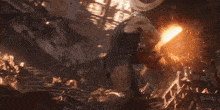 a man is standing in front of an explosion and holding a red cloth