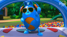 a blue toy dog wearing sunglasses and headphones is dancing in a ball pit .