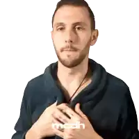 a man wearing a blue sweater with the word mcdh on the bottom right