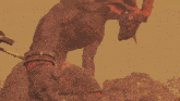 a statue of a monster with horns and a chain around its wrist